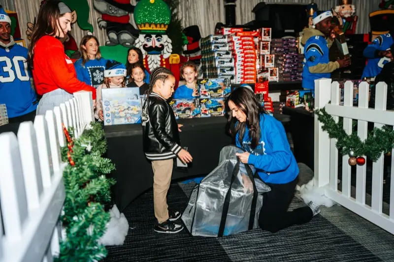 A student picks out toys with help from volunteers in the toy shop